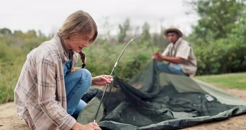 Two Friends Setting Up a Tent in Nature