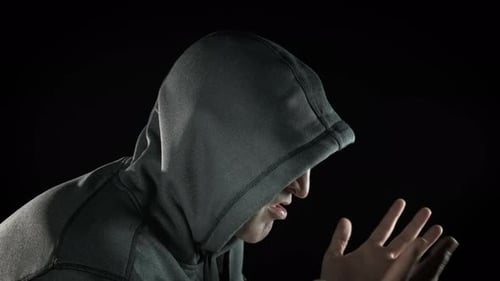Adult in Hooded Sweatshirt Hiding Face in Hands