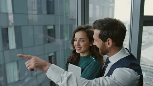 Business Couple Colleagues Talking Joyfully About Work Standing in Modern Office Close