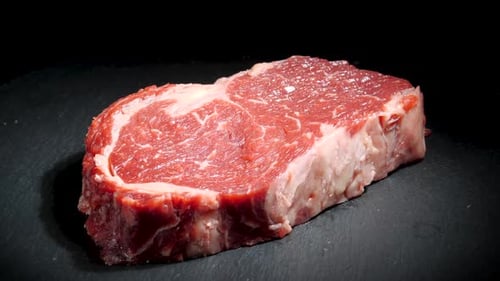 Steak Meat Rotating Background. Raw Beef Ribeye Close Up Video Backdrop. Food Concept