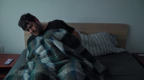 Homme endormi sortant du lit le matin avec une expression fatiguée et tendue