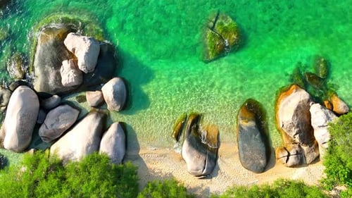 Stunning sandy beach with rock, clean sea water and green forest. 4K.