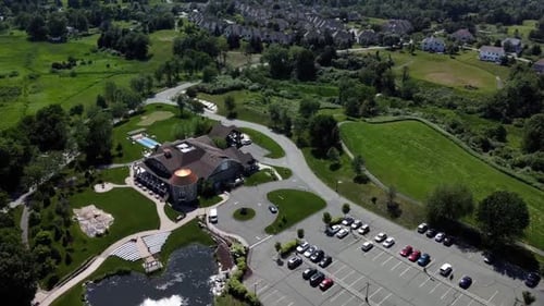 Aerial Drone rotating view of a banquet house for celebrations and weddings, surrounded by green lan
