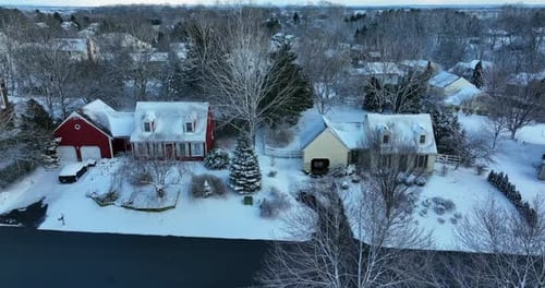 Truck shot of Cape Cod homes covered in winter snow. Residential suburban development.