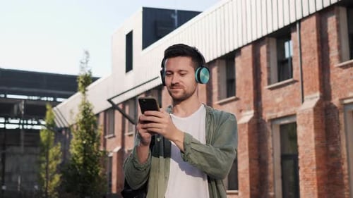 Man Choosing Song in Mobile App Outdoor