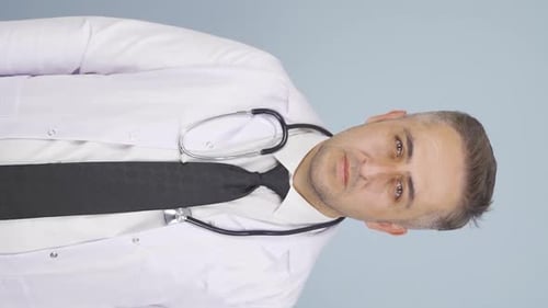 Vertical video of The doctor looks at the camera with a plain expression.