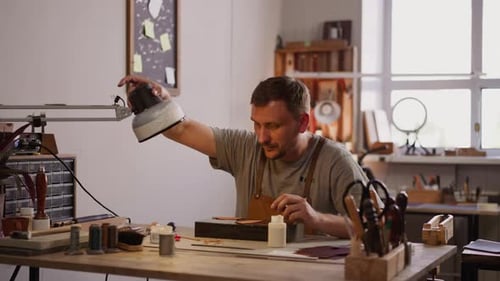 Man Crafting Leather at a Workbench