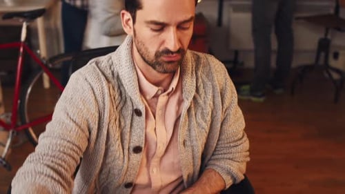 4k video footage of a young designer writing notes while going through blueprints in an office