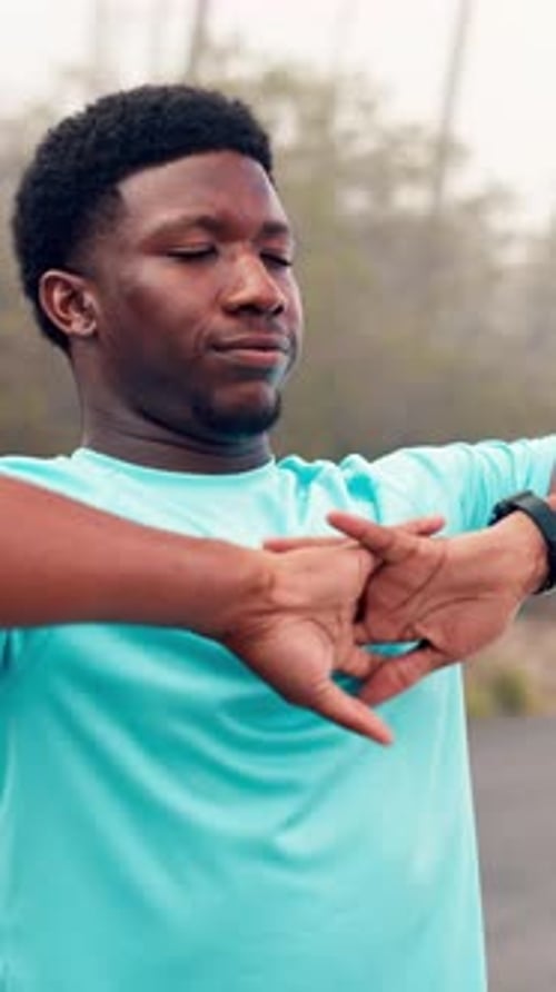 Young Man Stretching Arms Outdoors Before a Run