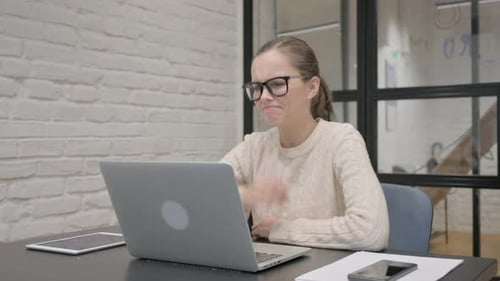 Frustrated Woman Working at Laptop in Office