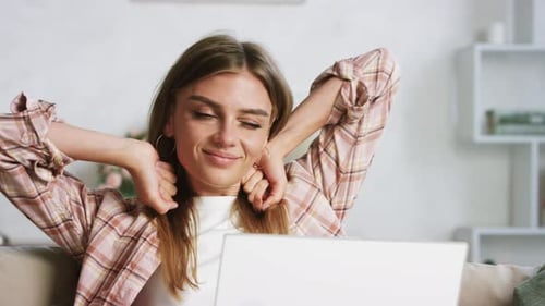 Woman Stretches While Using Laptop at Home