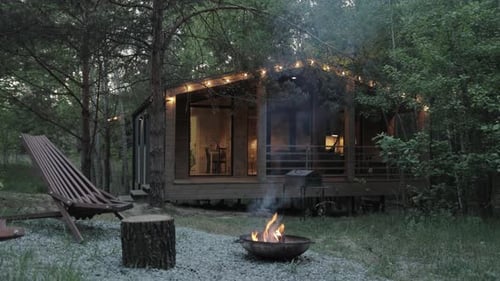Cabin in the Woods with Campfire at Night