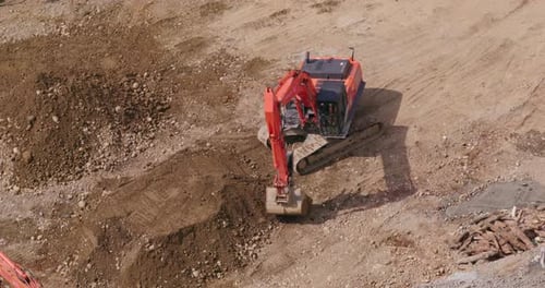 Excavator Digging and Moving Dirt on Construction Site