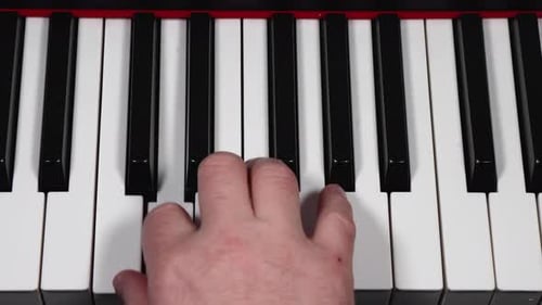 Aufnahme eines männlichen kaukasischen Mannes, der seine Hand beim Klavierspielen zeigt