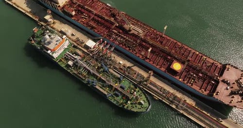 Oil tankers unloading crude oil in a port terminal.
