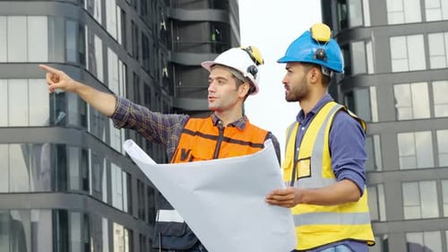 Engineers Reviewing Blueprints on Construction Site