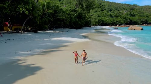 Couple on the Beach of Anse Lazio Praslin Island Seychelles on a Sunny Morning
