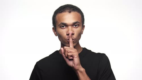 Man Making Silence Gesture with Finger on Lips