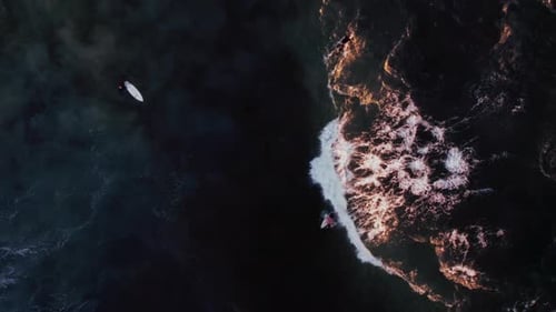 Aerial View of a Men Surfing at Sunset on the Ocean