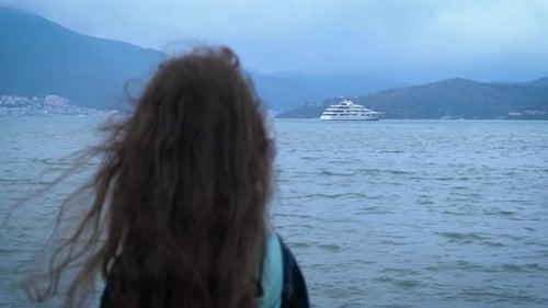 Woman Gazing at Yacht on the Coast