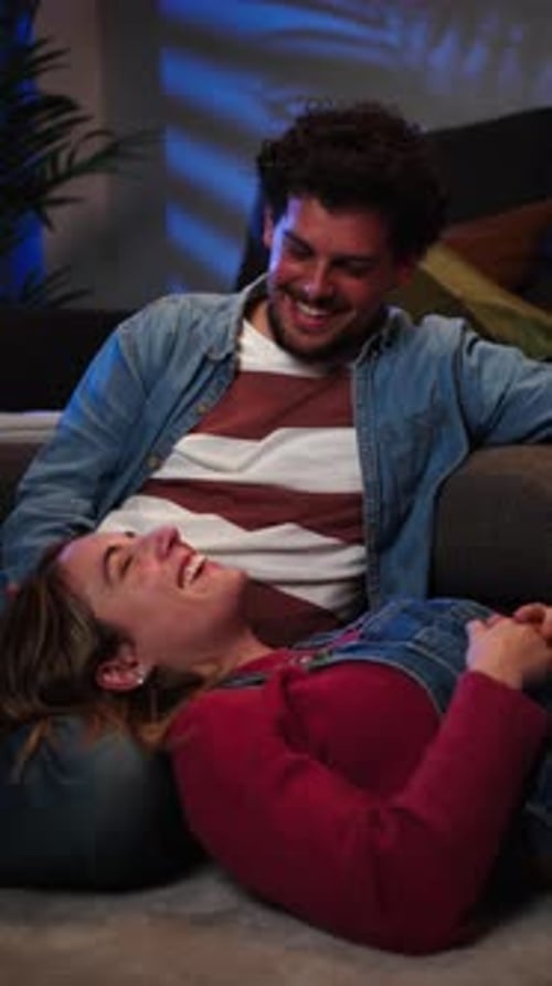 Vertical View of Young Caucasian Couple Smiling and Looking at Each Other Resting Sitting on the