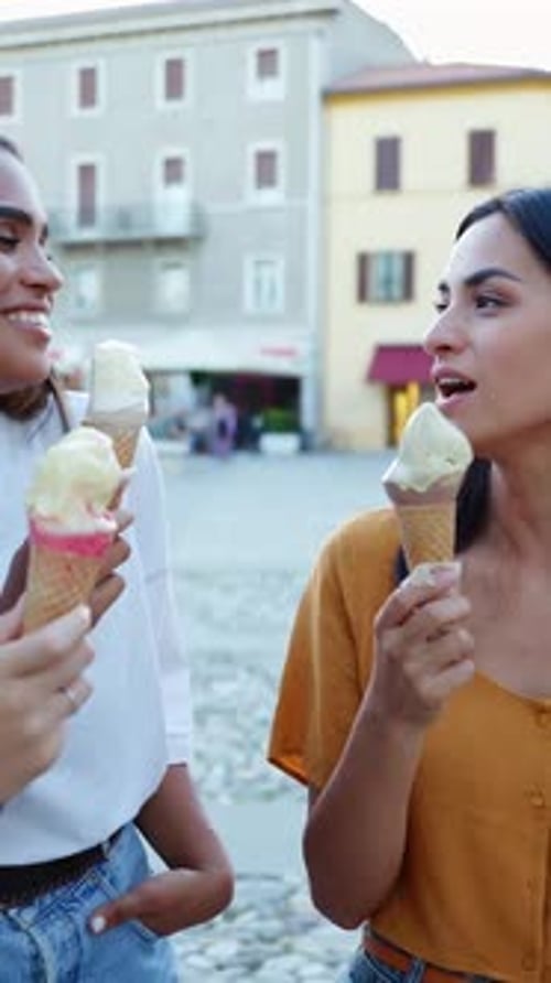 Three Young Tourist Women Eating Ice Cream Together at City Street