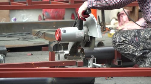 Handwerker schneidet ein verzinktes Eisenrohr aus Metall mit Trennmaschine Seitenansicht
