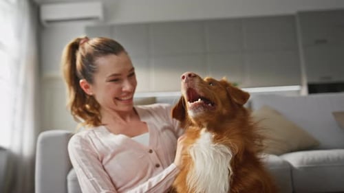 Woman Hugging Adorable Dog with Happy Smile at Home Close Up Girl Caressing Pet
