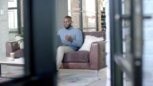 Young Adult Video Conferencing on Laptop in Modern Apartment