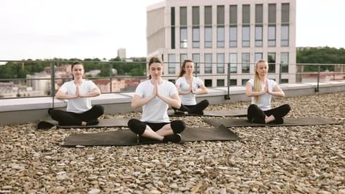 Young Women Practicing Yoga on a Rooftop