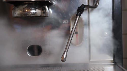Steam escaping an espresso machine in a cafe