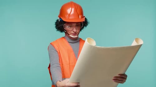 Front View of Attractive Serious Responsible Architect Designer in Orange Helmet