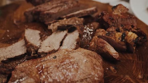 Closeup de carne suculenta aromática recém-assada com especiarias cuidadosamente cortadas em pedaços polvilhadas com sal