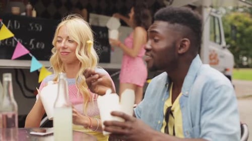 Friends Enjoying Food Truck Meal Together Outdoors
