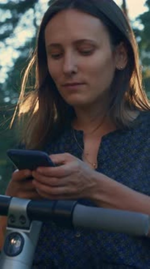 Woman Using Phone by Electric Scooter in Woods