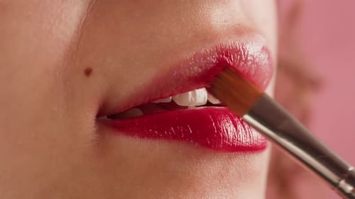 Woman Applying Red Lipstick with Brush Close Up