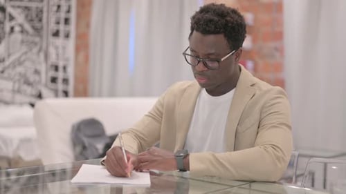 Person Writing on a Piece of Paper