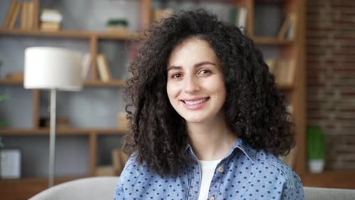 Smiling Woman with Curly Hair Looks into Distance