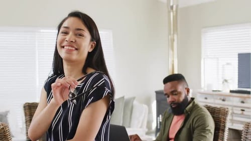 Femme biraciale souriante et amis féminins et masculins divers travaillant à la maison, Ralenti