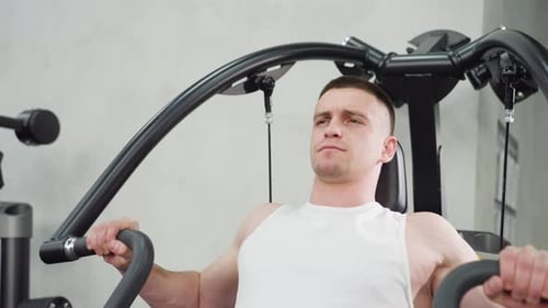 Man Using Chest Press Machine at the Gym