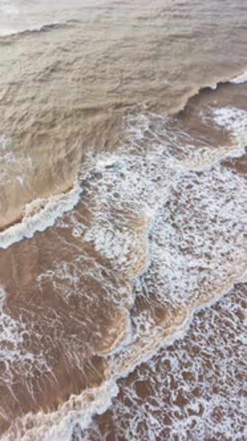 Waves crashing on the shore in Tra Vinh, Vietnam, during daylight hours.