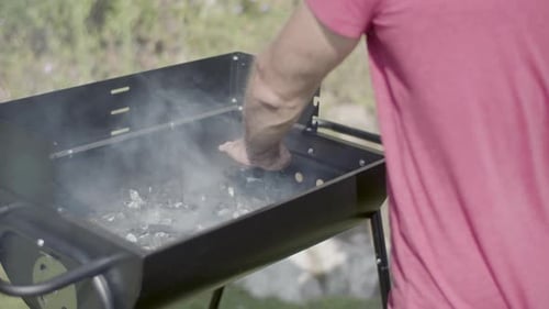 Closeup of Man Feeling Heat Over Barbeque Grill