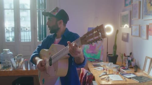 Talented Man Playing the Guitar Music in Art Studio