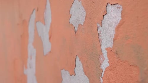 Peeling Paint on an Orange Wall in a Quiet Outdoor Area