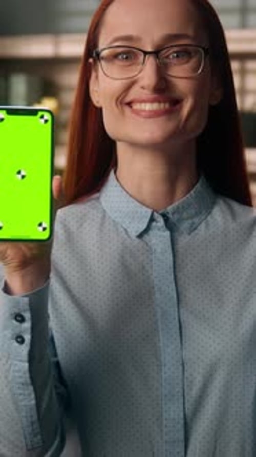 Smiling Caucasian Business Woman Showing Thumb Up Pointing at Phone Green Screen Indoor Office Happy