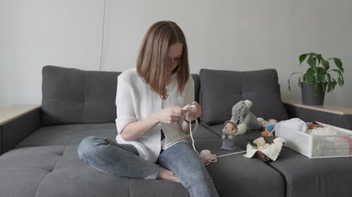 Woman Crocheting on Couch During the Daytime