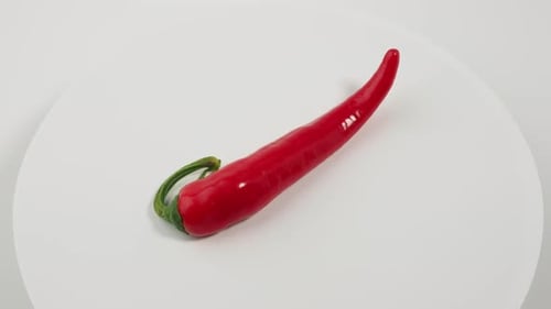 Single Red Chili Pepper Rotating on White Platform