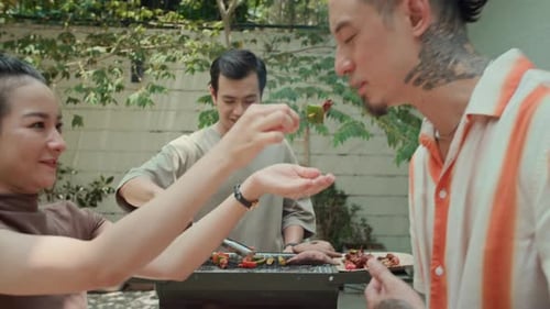 Young Adults Sharing a BBQ in Backyard