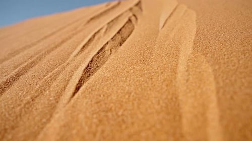 Goldene Sanddünen mit komplizierten Mustern unter klarem blauem Himmel