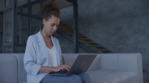Woman Works on Laptop in Modern Home Interior